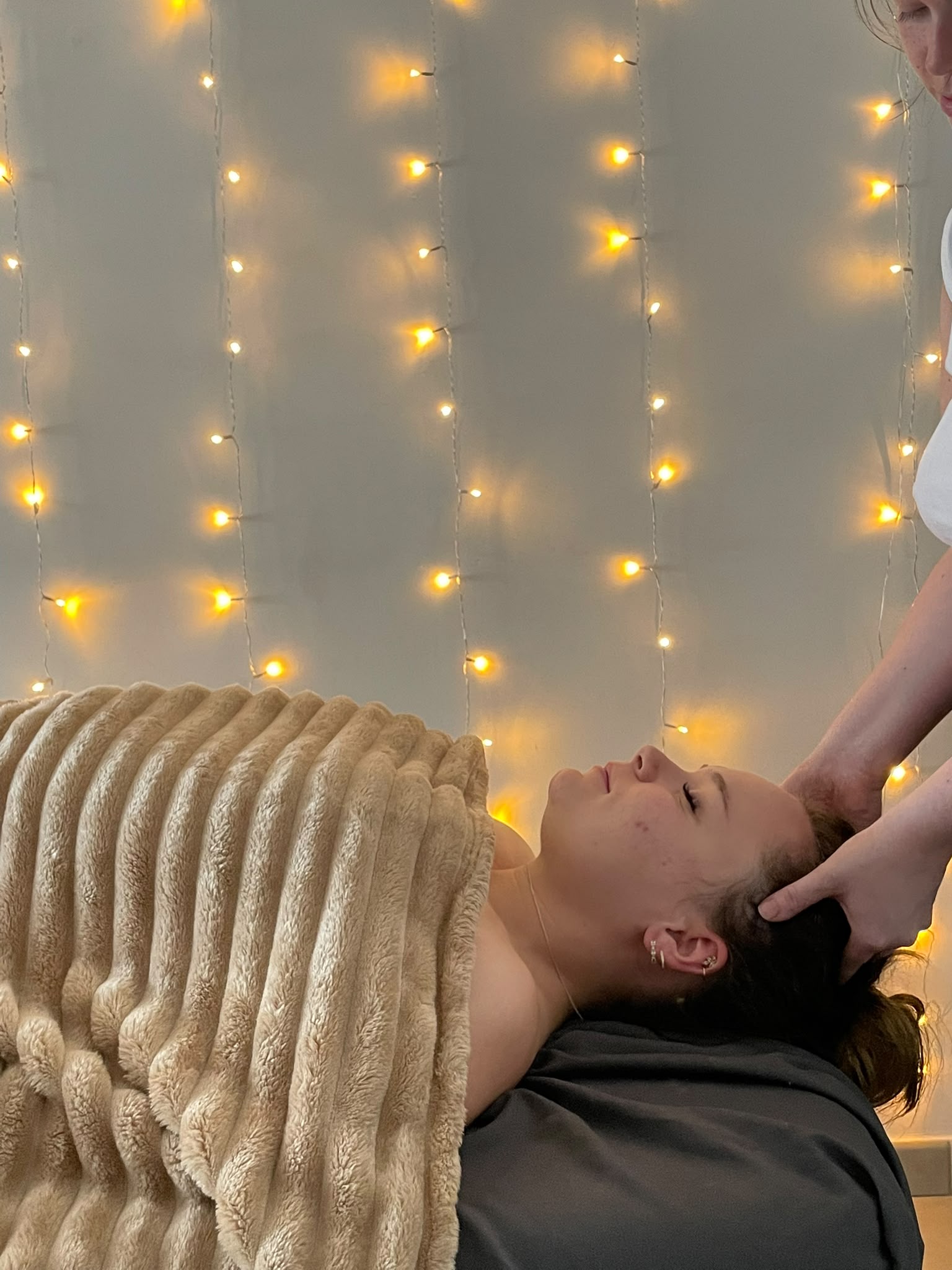 Massage du cuir chevelu et de la nuque, cliente allongée sous une couverture